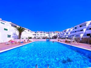 a large swimming pool in front of some apartment buildings at Tropicalidays Sunset Palm in Costa Del Silencio