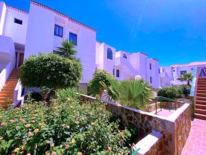 a row of buildings with trees and flowers in front at Tropicalidays Sunset Palm in Costa Del Silencio