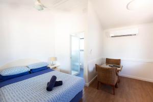 a bedroom with a bed with a pair of black shoes on it at Ningaloo Caravan and Holiday Resort in Exmouth