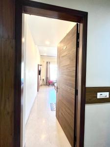 a wooden door leading into a hallway with a room at The Woodlark !! Managed by Sidham Hospitality !! in Chandīgarh