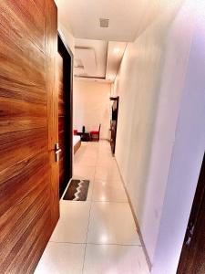 a hallway with a wooden door and a tile floor at The Woodlark !! Managed by Sidham Hospitality !! in Chandīgarh