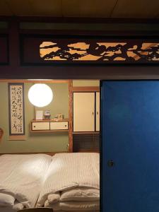 1 dormitorio con 1 cama y puerta azul en Tokushima - house / Vacation STAY 573, en Tokushima