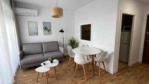 uma sala de estar com um sofá, uma mesa e cadeiras em Kione Las Margaritas em Alcossebre
