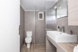 um banheiro com uma pia branca e um vaso sanitário em City Nexus Family 2BD residence Kolonos, Athens em Atenas mais 27 fotografias