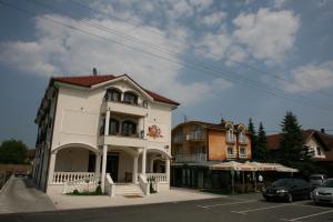 ein weißes Gebäude mit Balkon auf einer Straße in der Unterkunft Hotel Villa Viktorija in Banja Luka