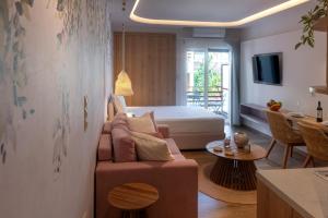 Loutraki Flamingo Feather في لوتراكي: غرفة معيشة مع أريكة وسرير