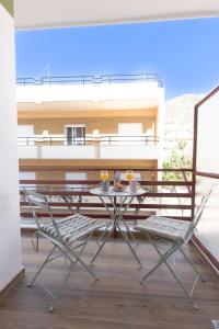 una mesa y sillas sentadas en un balcón en Loutraki Flamingo Feather en Loutráki