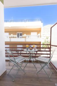 une table et des chaises assises sur un balcon dans l'établissement Loutraki Flamingo Feather, à Loutraki