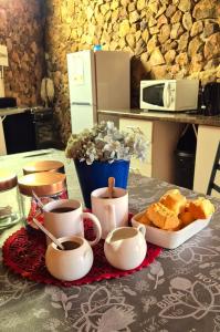 a table with coffee cups and a tray of bread at Hide Away Wedding,Conference & Function Venue in Bela-Bela