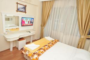 a bedroom with a bed and a desk and a mirror at YILDIZHAN HOTEL in Pamukkale