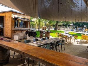 un patio con mesa y sillas y un bar en Hôtel Karène, en Saint-Paul-lès-Romans