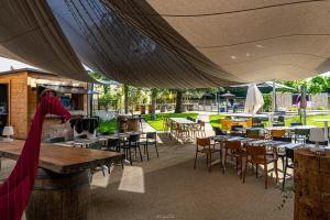 an outdoor patio with tables and chairs and tables and tablesearcher at Hôtel Karène in Saint-Paul-lès-Romans