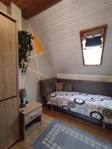 um pequeno quarto com uma cama e uma janela em Dorina Apartman em Zalakaros
