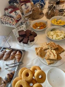 uma mesa cheia de diferentes tipos de pastelarias e sobremesas em Quattro Gigli Palace em Montopoli in Val dʼArno