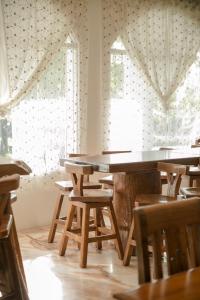 einen Tisch und Stühle in einem Zimmer mit Fenstern in der Unterkunft Alps Garden B&B in Wujie
