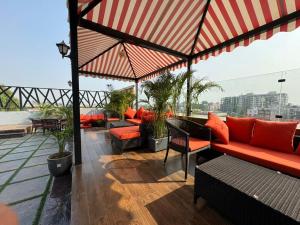 a rooftop patio with red furniture and a view of a city at Hotel Tamarind Tree in Kharar