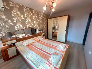 a bedroom with a large bed and a mirror at Lux Apartment Sisi in Burgas City