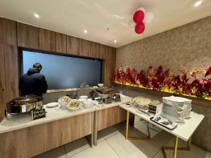 a man standing in front of a television in a kitchen at Hotel Tamarind Tree in Kharar