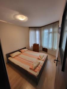 ein Schlafzimmer mit einem großen Bett und einem Fenster in der Unterkunft Lux Apartment Sisi in Burgas City