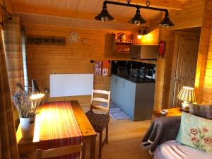 a living room with a table and a kitchen at Beckside Lodge in Malton