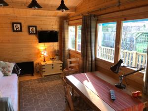 a living room with a desk in a log cabin at Beckside Lodge in Malton