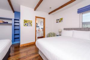 ein Schlafzimmer mit einem großen weißen Bett und einem Fenster in der Unterkunft An Capall Dubh B&B Dingle in Dingle