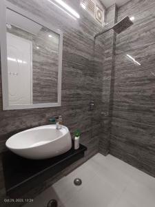 uma casa de banho com um lavatório branco e um espelho. em Sardar House em Nova Deli