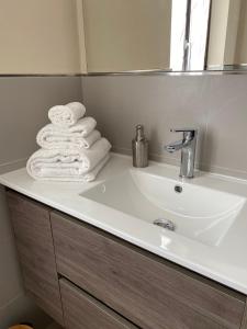 a bathroom sink with towels on top of it at Casa Rubbo - Appartamento in collina 'Monviso' in Alba +14 photos