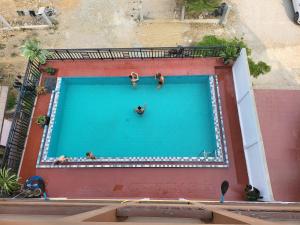 a group of people swimming in a large swimming pool at Vangvieng Sisavang Mountain View Hotel in Vang Vieng