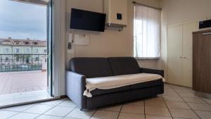 a living room with a couch and a sliding glass door at Fiori sull'Acqua Apartments in Peschiera del Garda