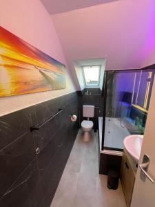 baño con lavabo y aseo y ventana en Grace Apartment, en Grömitz