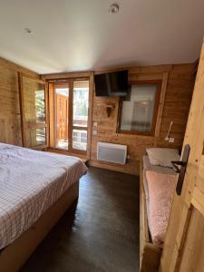 a bedroom with a bed and a television in a cabin at Meribel 17 in Méribel