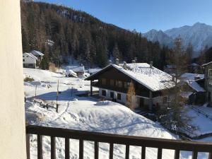 una casa en la nieve con una valla en Appartamento Saint-Jacques des Allemands, en Champoluc