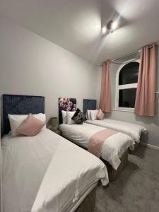 1 Schlafzimmer mit 2 Betten und einem Fenster in der Unterkunft Welsh Getaway Apartment - Town Centre in Merthyr Tydfil