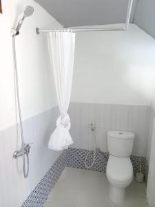y baño con aseo y cortina de ducha. en Alice Villa2, en Tuk Tuk