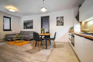 Apartman La Glace في مارتين: مطبخ وغرفة معيشة مع طاولة وكراسي