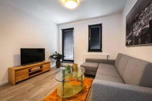 a living room with a couch and a flat screen tv at Apartman La Glace in Martin