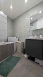 ein Badezimmer mit einer Badewanne, einem Waschbecken und einer Badewanne in der Unterkunft Appartement lumineux et cosy avec balcon - 3P in Les Lilas