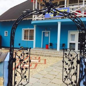 a blue house with a gate in front of it at Kék Lagúna Wellness Apartmanok in Egerszalók