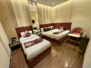a hotel room with two beds and a chair at Hotel 51 in Amritsar