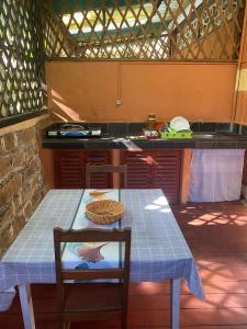 a kitchen with a table and a table and a counter at Spices Beach Studio Madirokely Nosy Be in Nosy Be