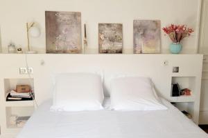 a bedroom with a white bed with two pillows at Villa Libellules lac et mer in Soorts-Hossegor