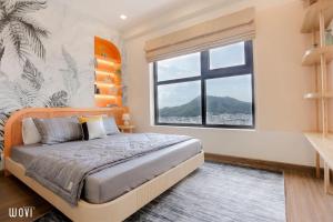 a bedroom with a bed and a large window at Wins House - FLC Sea Tower Quy Nhơn in Quy Nhon