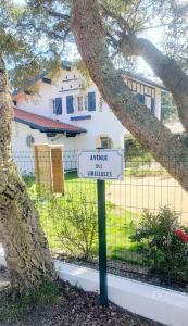 ein Schild vor einem Haus mit einem Baum in der Unterkunft Villa Libellules lac et mer in Soorts-Hossegor