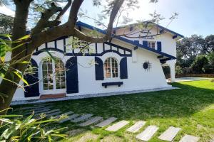 ein Haus mit einer blau-weißen Fassade in der Unterkunft Villa Libellules lac et mer in Soorts-Hossegor