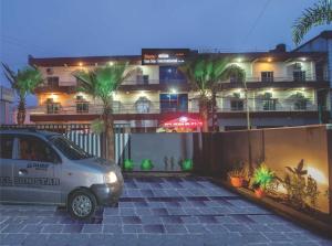 a car parked in a parking lot in front of a building at Sun Star International Hotel 24/7 in Bhairāhawā