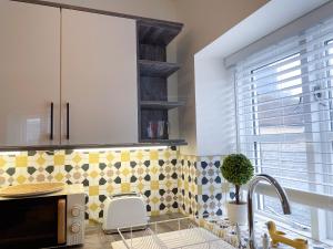 a kitchen with a sink and a microwave at Exclusive 1 and 2 Bedroom Flats only 0,5 miles away from Bicester Village in Bicester +96 photos