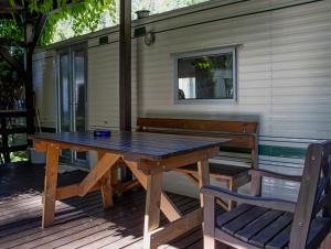 stół piknikowy i ławka na pokładzie w obiekcie Camping Karolina w mieście Planá