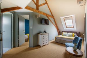 een slaapkamer met een bed, een tafel en een stoel bij LE CLOS POULAIN Petits gîtes de charme et chambres d'hôtes Familiales au calme proche Bayeux et des plages in Nonant