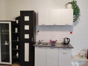 a kitchen with white cabinets and a sink at Apartmán Dolina in Banská Belá
